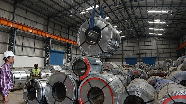 

Indian workers store steel coils unloaded at a new private freight terminal near Ahmedabad. (SAM PANTHAKY/AFP/GettyImages)