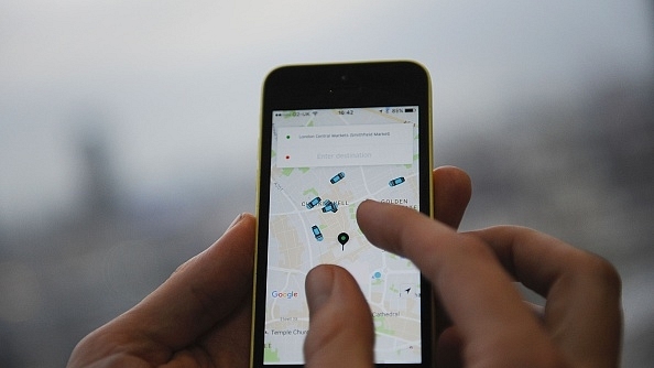 

A man  holding a smartphone showing the App for ride-sharing cab service Uber. (DANIEL SORABJI/AFP/Getty Images)