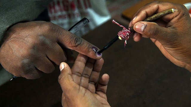 An Indian election officer marks the finger of a voter at a polling station. (PRAKASH SINGH/AFP/Getty Images) 