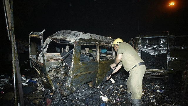 

An Indian policeman inspects the wreckage of a vehicle following a blast at Sarojini Nagar market, 29 October 2005 in New Delhi. (RAVEENDRAN/AFP/Getty Images)