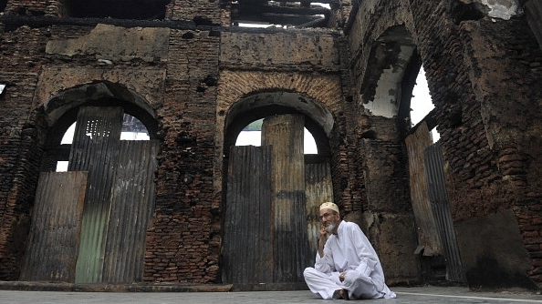 

A Kashmiri Muslim sits next to the ruins of a revered 200-year old sufi shrine in Srinagar. (TAUSEEF MUSTAFA/AFP/GettyImages)