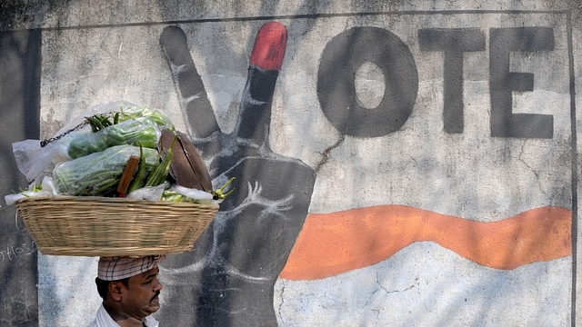 A vegetable vendor walks past graffiti urging Indians to vote, in Mumbai. (INDRANIL MUKHERJEE/AFP/Getty Images)