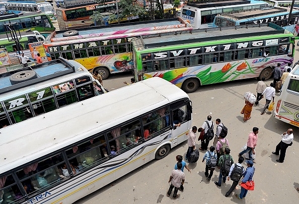 

Passengers waiting to board private buses. (Photo Credit:MANJUNATH KIRAN/AFP/Getty Images)