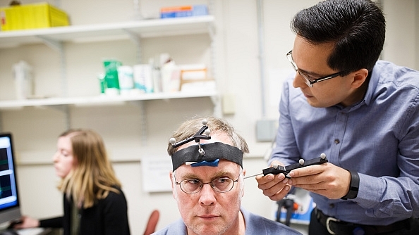 

Research fellow Ali Jannati simulates a TMS therapy session on John Elder Robison as he sits in the room where he took part in brain therapy known as TSM (Transcranial magnetic stimulation) at Beth Israel Hospital in Boston, Mass. (Keith Bedford/The Boston Globe via Getty Images)