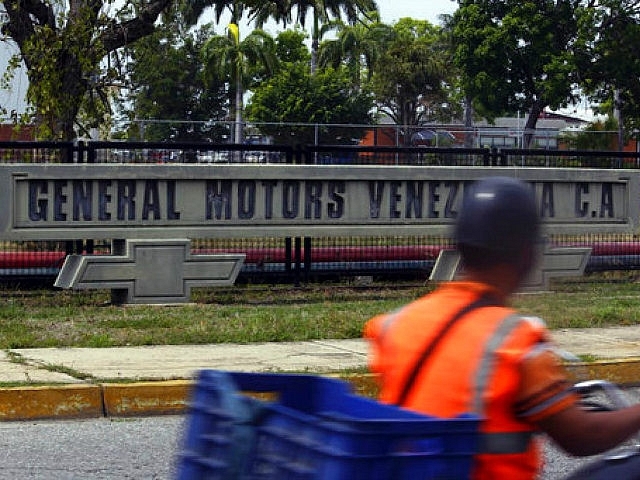 A motorcyclist rides past the General Motors’ plant in Valencia, Venezuela.

