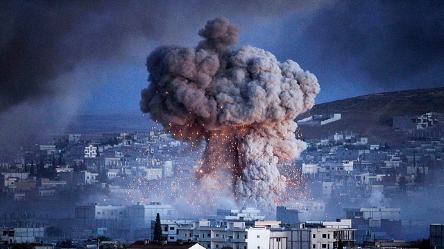 

An explosion rocks Syrian city of Kobani during a reported suicide car bomb attack by the militants of Islamic State (ISIS) group on a People’s Protection Unit (YPG) position in the city center of Kobani, as seen from the outskirts of Suruc, on the Turkey-Syria border, October 20, 2014 in Sanliurfa province, Turkey. According to Foreign Minister Mevlut Cavusoglu, Turkey will reportedly allow Iraqi Kurdish fighters to cross the Syrian border to fight Islamic State (IS) militants in the Syrian city of Kobani while the United States has sent planes to drop weapons, ammunition and medical supplies to Syrian Kurdish fighters around Kobani. (Photo by Gokhan Sahin/Getty Images)