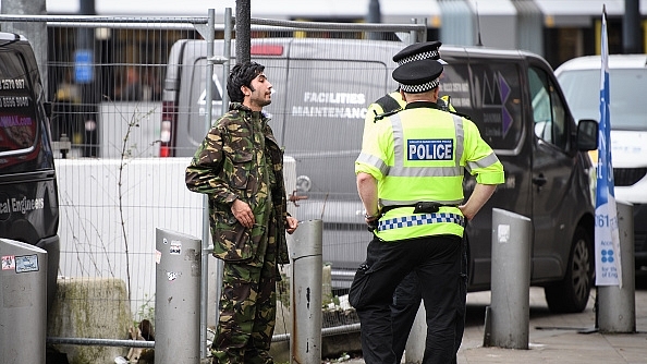 A man is stopped and searched by police as he walks in the city centre in Manchester, England. (Leon Neal/Getty Images)