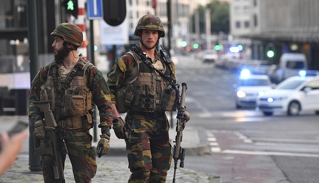 
Belgian Army soldiers approach a man outside Central Station after an explosion.

