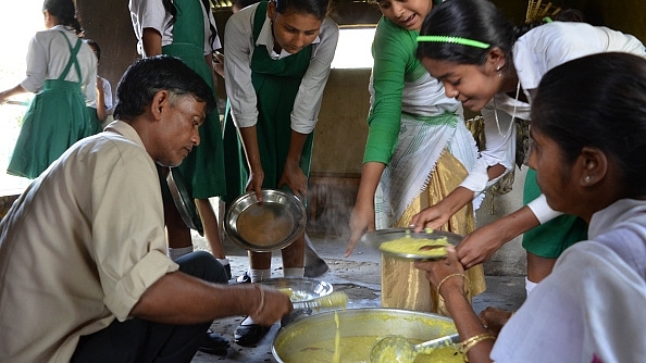 School girls receive a free mid-day meal at a government school. (Anuwar Ali Hazarika / Barcroft I via Getty Images)