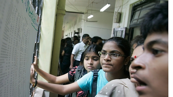 Students scan the merit list put out at their college in Dadar, Mumbai. (Kunal Patil/Hindustan Times via Getty/Images)