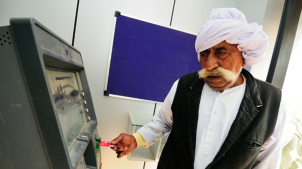 A villager uses an ATM machine to withdraw cash. (Priyanka Parashar/Mint via GettyImages) &nbsp;