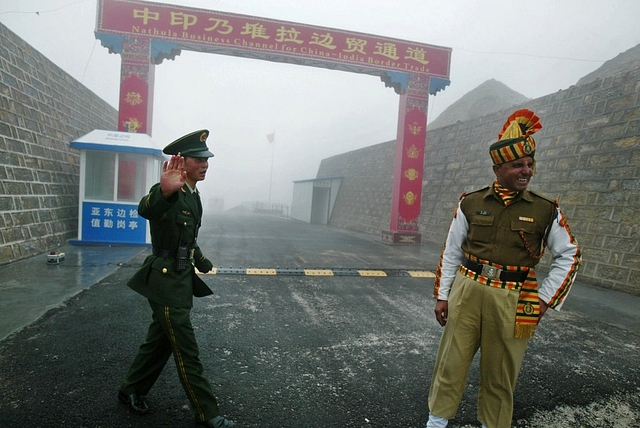 Indian and Chinese soldiers at a border crossing.                        
            (Diptendu Dutta/GettyImage)

