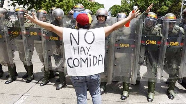 
A woman with a sign reading ‘There is no food’ protests against new emergency powers decreed by President Nicolás Maduro.

