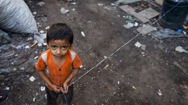 A young girl looks upwards as she plays with a piece of string in Mumbai. (Daniel Berehulak/Getty Images)