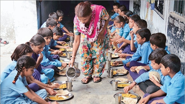 A caretaker serves mid-day meal to the students

