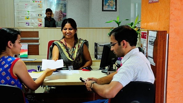 A bank official helps a customer. (Priyanka Parashar/Mint via GettyImages)