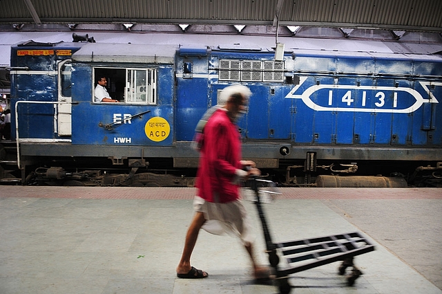 

A porter walking in front of a diesel rail engine at Howrah Station on February 26, 2015 in Howrah, India. (Indranil Bhoumik/Mint via Getty Images)