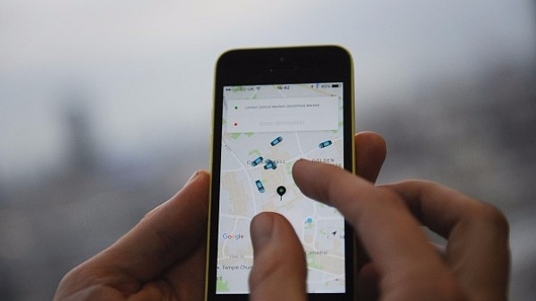 

A man  holding a smartphone showing the App for ride-sharing cab service Uber. (DANIEL SORABJI/AFP/Getty Images)