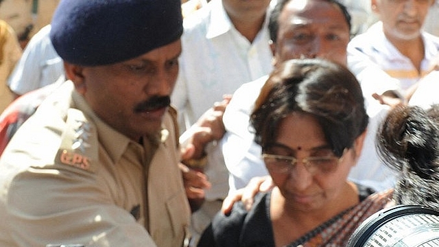 An Indian police officer escorts Kodnani after she surrendered to a special investigation team in Gandhinagar on 27 March 2009. (SAM PANTHAKY/AFP/Getty Images)