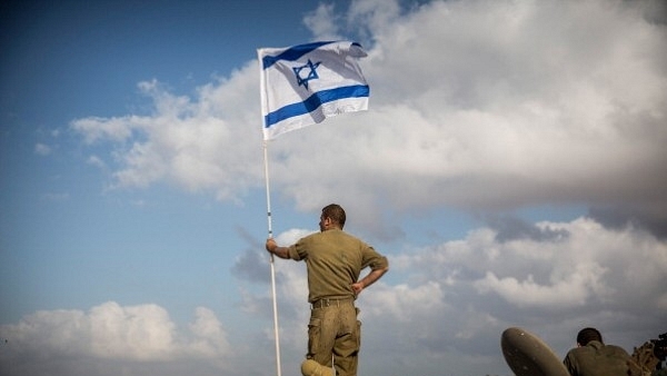 An Israeli soldier stands on top of an armoured personnel carrier near the Israeli-Gaza border in 2014 near Sderot, Israel. (Andrew Burton/Getty Images)