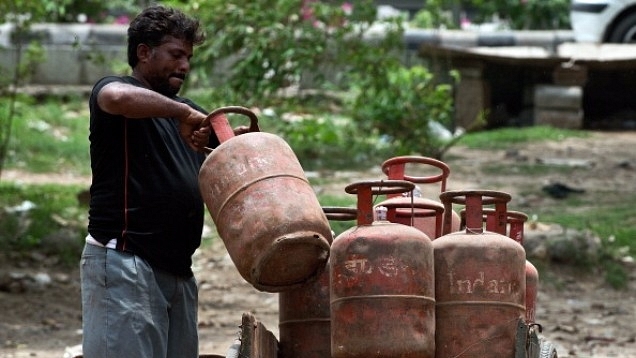 An Indian LPG vendor loads refilled gas cylinders onto a rickshaw. (PRAKASH SINGH/AFP/Getty Images)