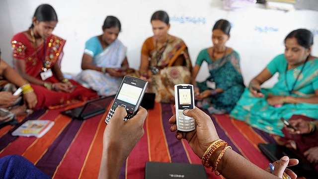 Indian villagers, part of a Self Help Group (SHG) organisation, pose with mobile phones and laptops in Bibinagar village outskirts of Hyderabad on March 7, 2013, on the eve of International Women’s day. (NOAH SEELAM/AFP/Getty Images)