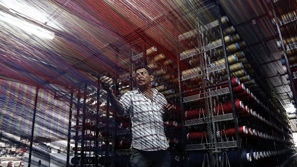 Indian worker checking thread reels on a carpet weaving machine at a factory on the outskirts of Jammu. (ALOK PATHANIA/AFP/Getty Images)