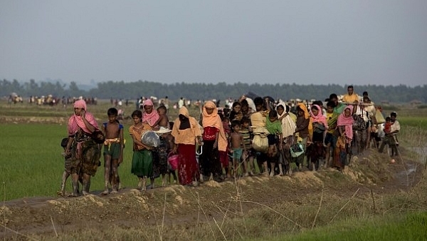 Displaced Rohingya refugees from Rakhine state in Myanmar carry their belongings as they flee violence, near the border between Bangladesh and Myanmar (K M ASAD/AFP/Getty Images)