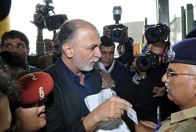  Tarun Tejpal shows his identity card to an official as he enters the airport in New 
Delhi. (STRDEL/AFP/Getty Images)

