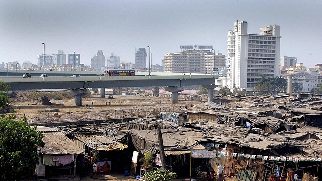 Residents go about their business in a colony of slum dwellings surrounding a newly-built flyover and high-rise apartments in the Bandra suburb of Mumbai. (SEBASTIAN D’SOUZA/AFP/GettyImages)