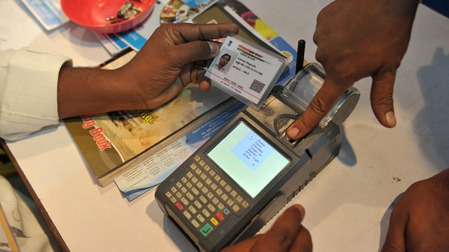 An Indian customer gives a thumb impression to withdraw money from his bank account with his Aadhaar card during a Digi Dhan Mela, held to promote digital payment, in Hyderabad. (NOAH SEELAM/AFP/GettyImages)