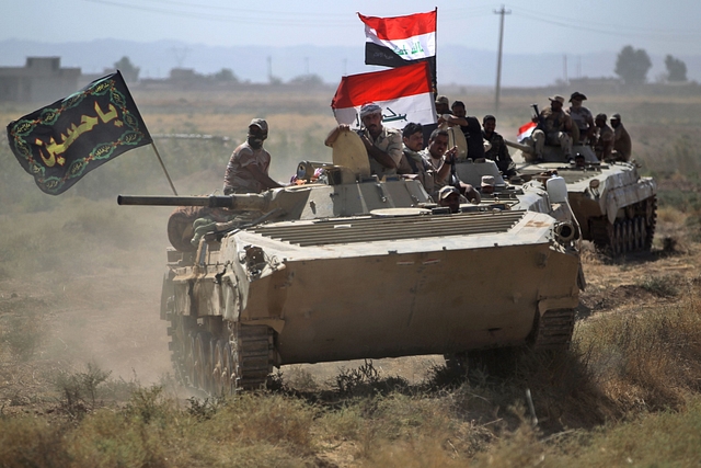 Iraqi forces remove a billboard bearing the logo of the Islamic State at Hawija (AHMAD AL-RUBAYE/AFP/Getty Images)