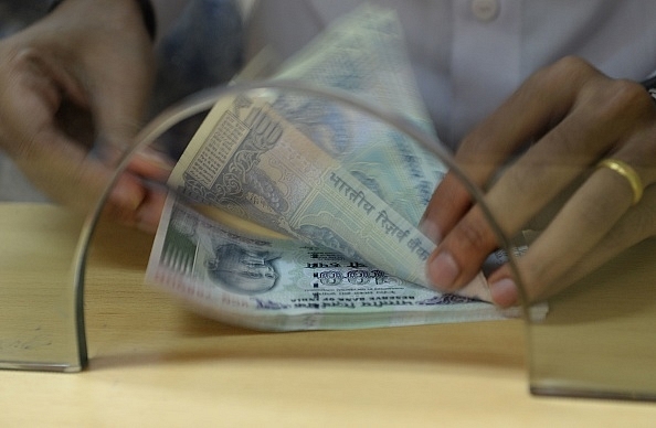 A customer counts Rs 100 currency notes after withdrawing money at a bank. (INDRANIL MUKHERJEE/AFP/Getty Images)