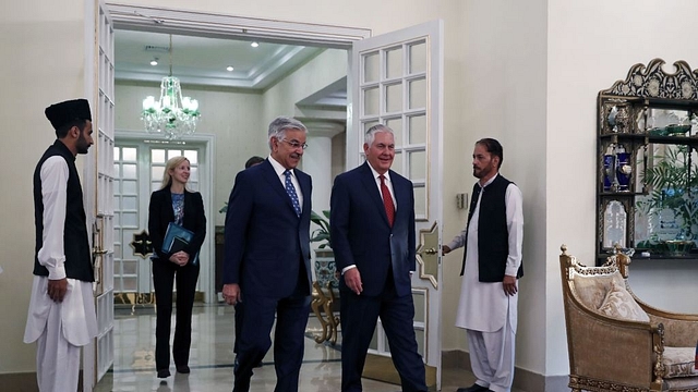 Rex Tillerson (second right) walks with  Khawaja Asif as he arrives at the Prime Minister’s residence in Islamabad on 24 October 2017. (ALEX BRANDON/AFP/GettyImages)