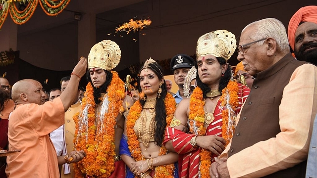 Uttar Pradesh CM Yogi Adityanath showers petals on artistes dressed up as Lord Rama, Sita and Lakshman in Ayodhya. (Deepak Gupta/Hindustan Times)