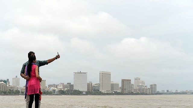 A young Indian couple take a ‘selfie’ on Marine Drive promenade in Mumbai. (INDRANIL MUKHERJEE/AFP/Getty Images)