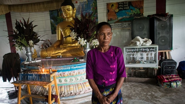 In this photograph taken on August 31, 2017 San Mae, 52, stands near a statue of Buddha at an internally displaced persons (IDP) camp in Sittwe. Rakhine, Myanmar’s poorest state, has become a crucible of religious hatred focused on the Muslim Rohingya, who are reviled and perceived as illegal immigrants in Buddhist-majority Myanmar. San Mae lives in Baw Di Kone in Rakhine State. This is the third time she has fled her village. (STR/AFP/Getty Images)