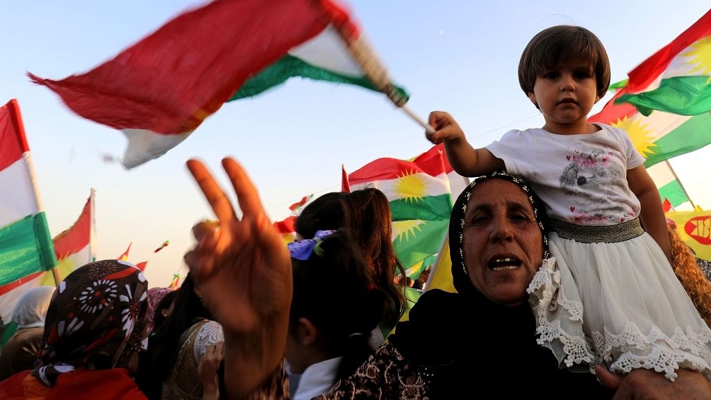 Syrian Kurds wave the Kurdish flag, in the northeastern Syrian city of Qamishli on 27 September 2017, during a gathering in support of the independence referendum in Iraq’s autonomous northern Kurdish region.&nbsp; (DELIL SOULEIMAN/AFP/GettyImages)