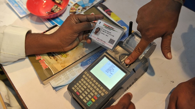 An Indian visitor gives a thumb impression to withdraw money from his bank account. (NOAH SEELAM/AFP/Getty Images)