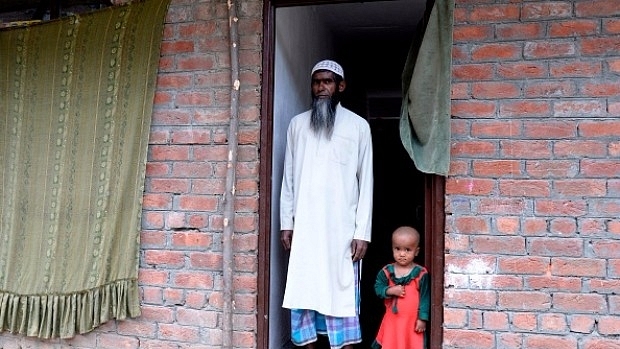 Rohingya refugee Haroon Rashid (L) poses with a child at the entrance to a building on the outskirts of Srinagar. (TAUSEEF MUSTAFA/AFP/Getty Images)