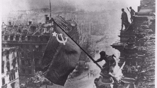 Russian soldiers flying the Red Flag, made from table cloths, over the ruins of the Reichstag in Berlin. (Yevgeny Khaldei/Getty Images)