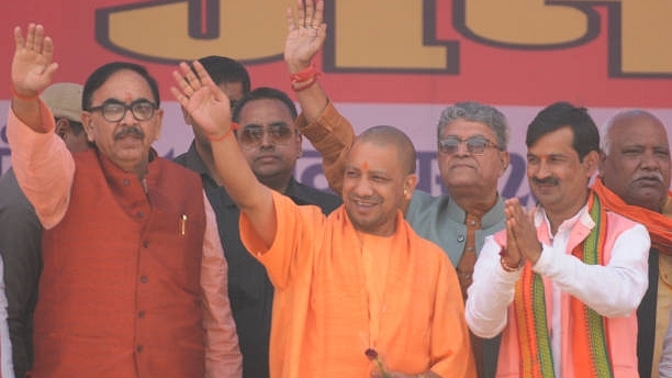 Chief Minister Uttar Pradesh Yogi Adityanath waves his hand to the crowd along with BJP state president Mahendra Nath Pandey and BJP mayor candidate for Ayodhya and Faizabad. (Deepak Gupta/Hindustan Times via Getty Images)