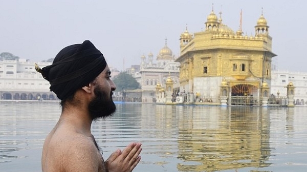 A Sikh devotee takes bath in the holy sarovar and pays obeisance at Golden Temple in Amritsar. (Sameer Sehgal/Hindustan Times via Getty Images)