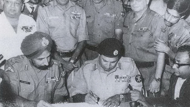 Lt Gen Niazi signing the Instrument of Surrender under the gaze of Lt Gen Aurora. (Indian Navy)