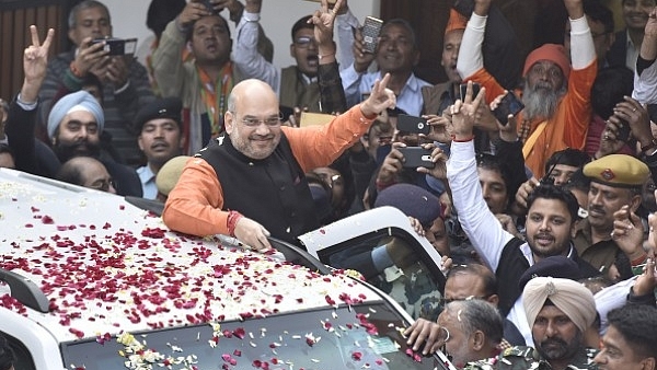 BJP national president Amit Shah greets party workers as they celebrate after the party is projected for victories in Gujarat and Himachal Pradesh elections. (Sonu Mehta/Hindustan Times via Getty Images)