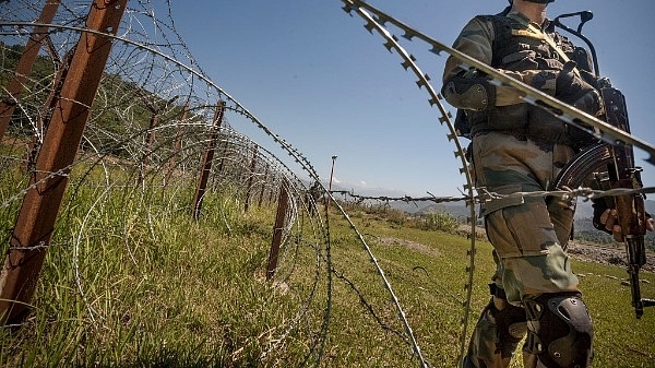 An Indian Army soldier patrols the fence near LoC  (Gurinder Osan/Hindustan Times via Getty Images)