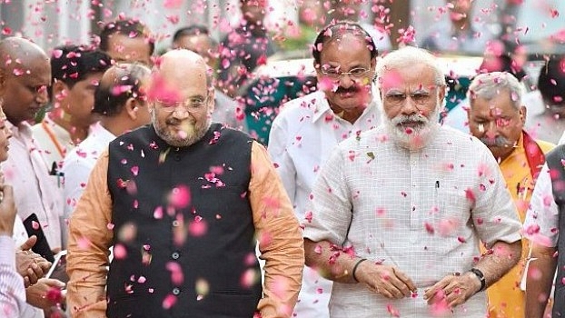 Prime Minister Narendra Modi and BJP president Amit Shah are welcomed at the party headquarters in New Delhi after the party scored significant victories in assembly polls. (Sonu Mehta/Hindustan Times via Getty Images)