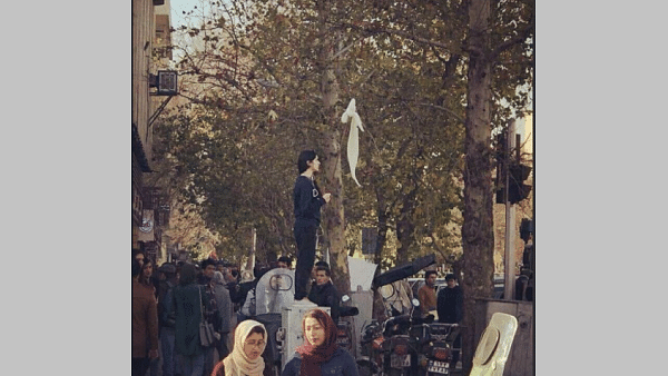 A woman waves a hijab during protests in Iran. (Twitter)