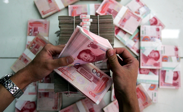 A clerk counts stacks of Chinese yuan at a bank in Beijing (China Photos/Getty Images)