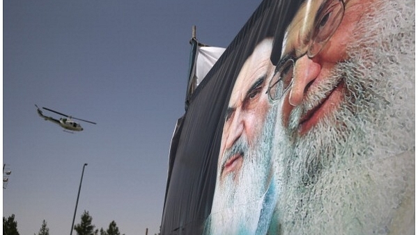  An Iranian police helicopter passes above portraits of Iran’s supreme leader Ayatollah Ali Khamenei (R) and the former Ayatollah Khomeini outside Khomeini’s shrine on the 25th anniversary of his death on June 4, 2014 (John Moore/Getty Images)